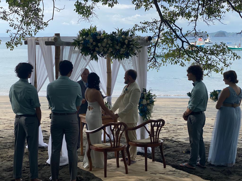 Ceremonia de boda en la playa con arco floral blanco